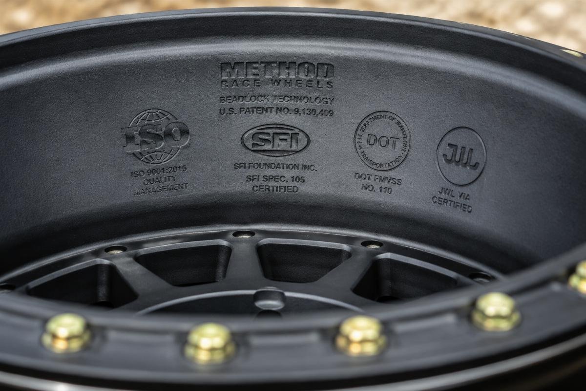 A close-up view of a certified off-road beadlock wheel with certification stamps visible on the inner barrel